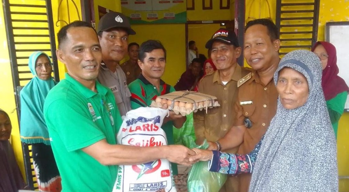 Kabid Distribusi Cadangan Pangan Achyarudin saat menyerahkan bantuan pangan miskin ekstrem di Kantor Desa Kuala Baru Sungai, Senin (20/5).