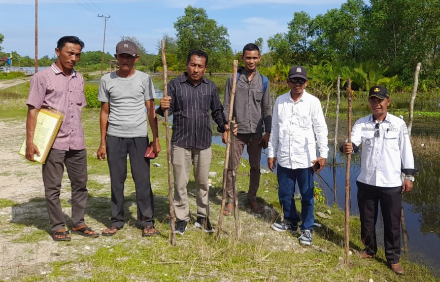 Tim Dinas Pertanahan Aceh Singkil didampingi Camat Kuala Baru Mansurdin dan perangkat desa saat melakukan verifikasi dan pemancangan perdana, lahan yang akan diusulkan untuk dibebaskan melalui Tora, Rabu (29/5/2024).